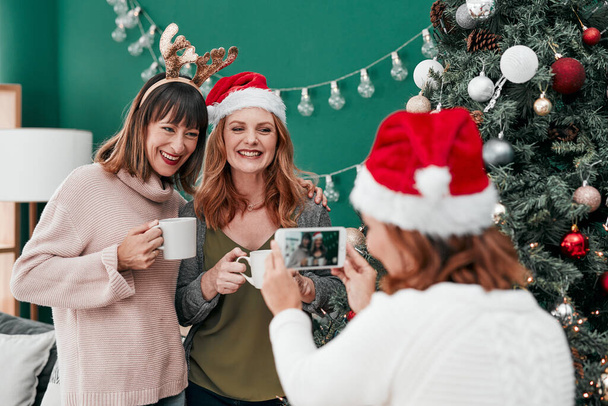 Ils sont stupéfiants. trois femme attrayante prenant des photos de Noël ensemble à la maison - Photo, image