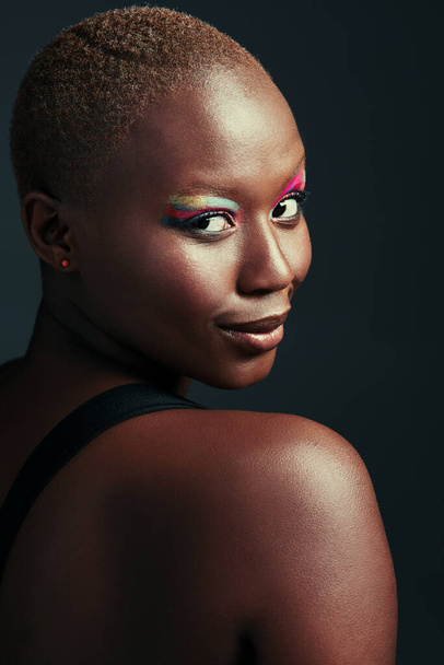 Just be yourself, darling. a beautiful woman wearing colorful eyeshadow while posing against a grey background - Fotó, kép