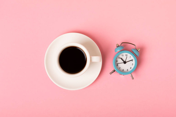 Cup of espresso coffee aroma and alarm clock on a pink background. Good morning concept. Top view with copy space for your text.Have a nice day. - Photo, Image