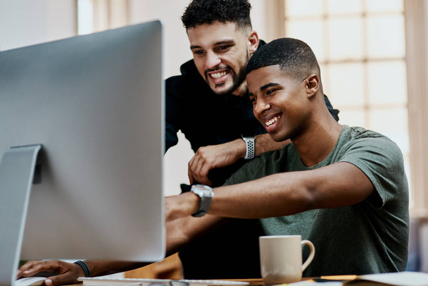 Raddoppia lo sforzo, raddoppia il successo. due giovani uomini d'affari che utilizzano un computer insieme in un ufficio moderno - Foto, immagini