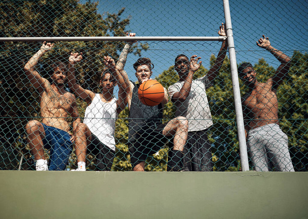 Gotowy do gry w piłkę. Portret grupy młodych sportowców opierających się o płot na boisku sportowym - Zdjęcie, obraz