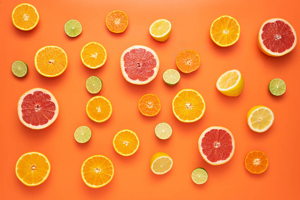 Fresh, Fruity and juicy fruit concept. View from top. Freshly cut slices citrus fruits on an orange background. - Foto, Bild