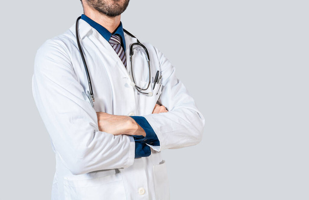 Young doctor with crossed arms isolated. Unrecognizable doctor with crossed arms on isolated background - Photo, Image