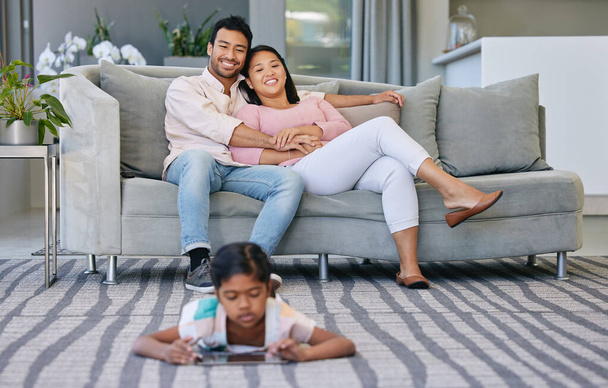 Manchmal braucht es ein wenig Ablenkung. ein junges Paar entspannt zu Hause, während ihre Tochter ein digitales Tablet benutzt - Foto, Bild
