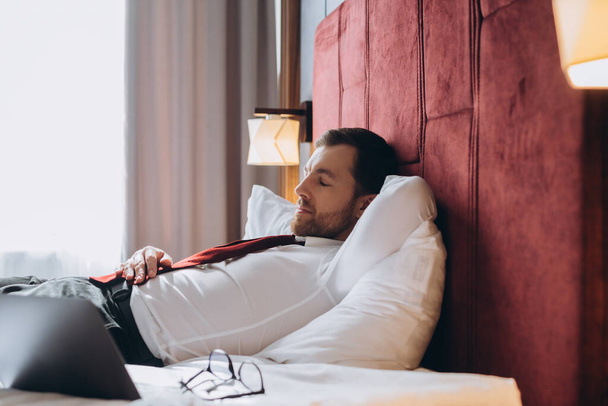Κουρασμένος επιχειρηματίας που αναπαύεται στο ξενοδοχείο roo - Φωτογραφία, εικόνα