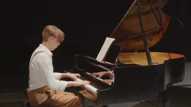 Средний кадр профессионального музыканта, играющего на рояле с открытой крышкой во время выступления на сцене - Кадры, видео