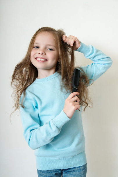 Little girl combing her hair - Fotó, kép