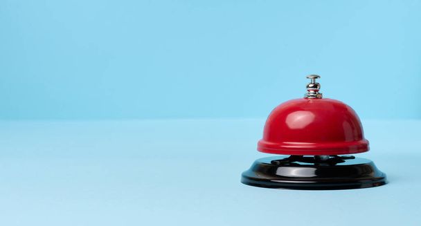Metallic red bell to call staff on a blue background, copy space - 写真・画像