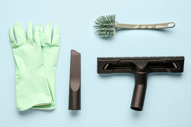 Stofzuiger opzetstukken met rubberen handschoenen en borstel op blauwe achtergrond - Foto, afbeelding