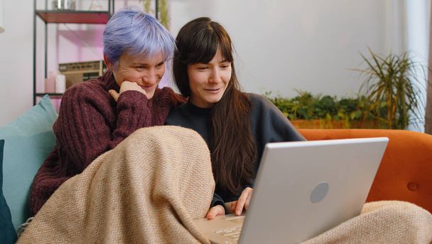 Két leszbikus nő pár vagy lányok barátok néz laptop kamera, hogy video webkamera konferencia hívás a családdal, élvezi a kellemes beszélgetést, nevetés, integetett hello otthon szobában. LMBT-személyek - Fotó, kép