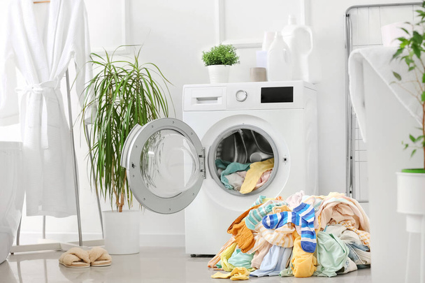 Empilement de vêtements sales et machine à laver dans la buanderie - Photo, image