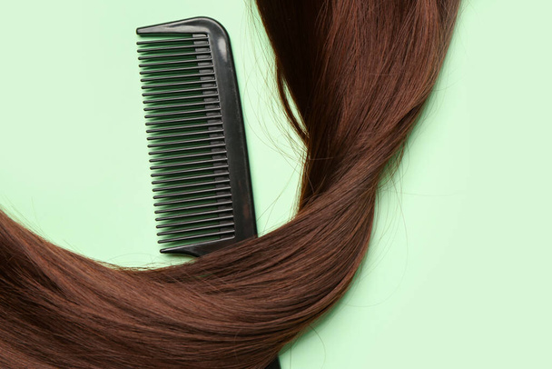 Brown hair with comb on green background - Foto, immagini
