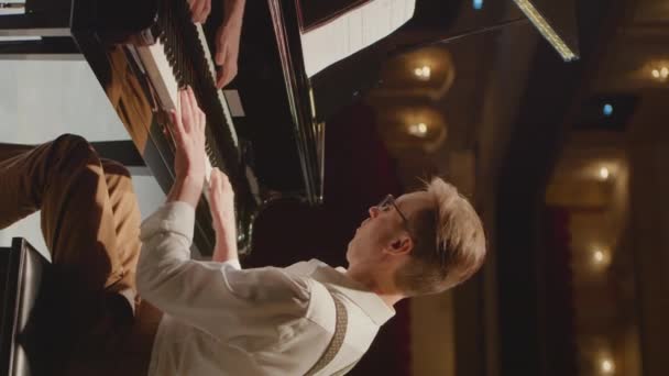 Sahnede konser salonunda piyano çalan profesyonel müzisyenin dikey çekimi. - Video, Çekim