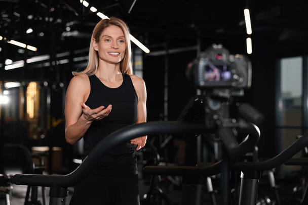 Fitness trainer recording online classes in gym - Zdjęcie, obraz
