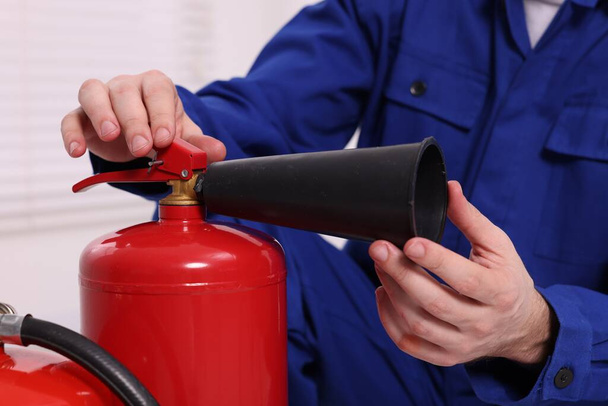 Man checking quality of fire extinguishers indoors, closeup - Фото, зображення