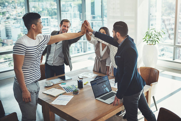 Success is inevitable if everyone gives their best. a diverse group of businesspeople high fiving in an office - Foto, Imagen