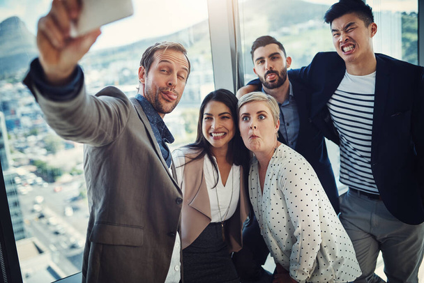 Letting all their expressions out. a group of businesspeople taking a selfie together in an office - Valokuva, kuva