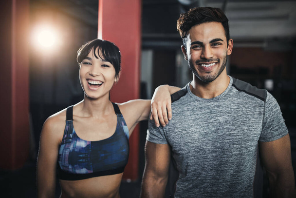 Its easy to keep our workouts fresh and enjoyable. a sporty young man and woman standing together in the gym - Foto, Imagem
