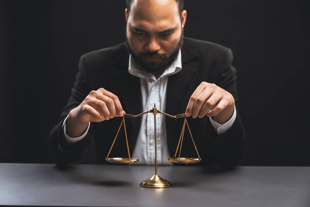 Focus scale balance with blur lawyer sitting at his desk with worried and exhausted expression, feeling weight of pressure and stress of making hard decision on verdict. equility - 写真・画像