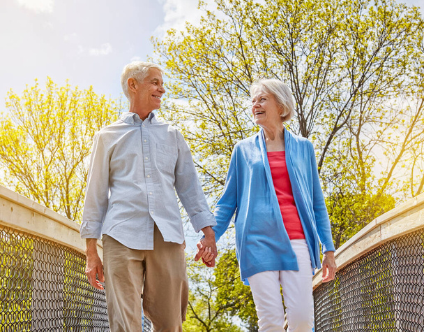 A szerelem fiatalon tartja a lelket. egy boldog nyugdíjas pár, akik együtt sétálnak a szabadban. - Fotó, kép