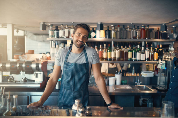 What can I make for you today. Portrait of a young man working behind a bar counter - Fotografie, Obrázek
