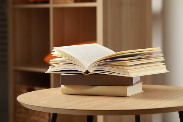 Pila di libri diversi su tavolo di legno all'interno, spazio per testo - Foto, immagini