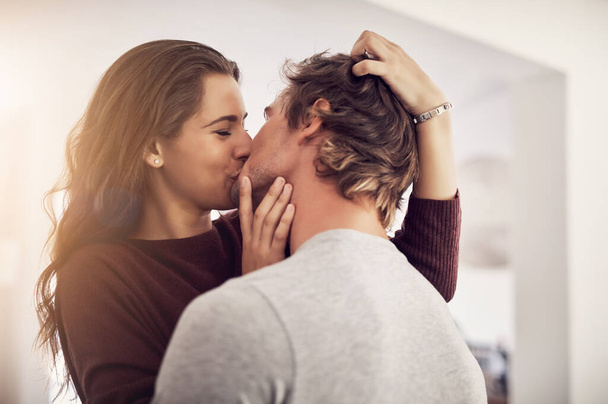 Potrei baciarti tutto il giorno. un affettuoso giovane coppia baci in cucina a casa - Foto, immagini