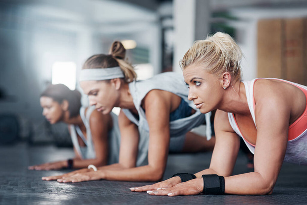 Bądź najlepszy, jaki możesz być. trzy kobiety robiące pompki na siłowni - Zdjęcie, obraz