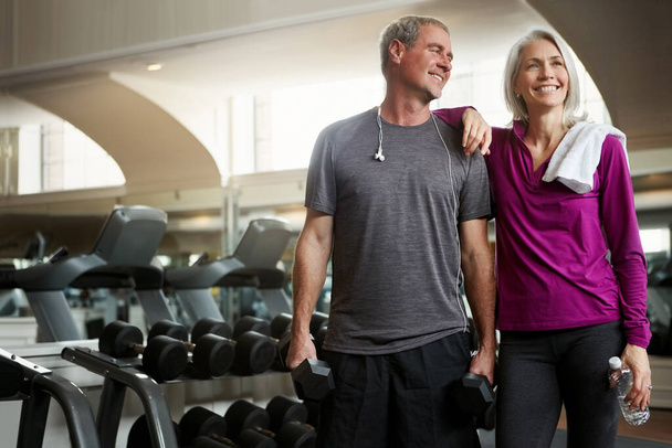 Laughing is a great exercise. a senior married couple laughing and taking a break from their workout at the gym - Photo, image