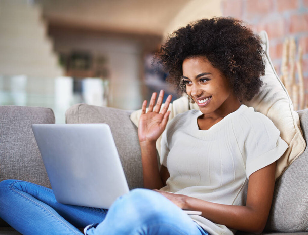 Relax, video call and woman on a couch, laptop and connection at home, happiness and communication. Female person, model or girl with technology, network and wave on a sofa, greeting and digital chat. - Foto, imagen