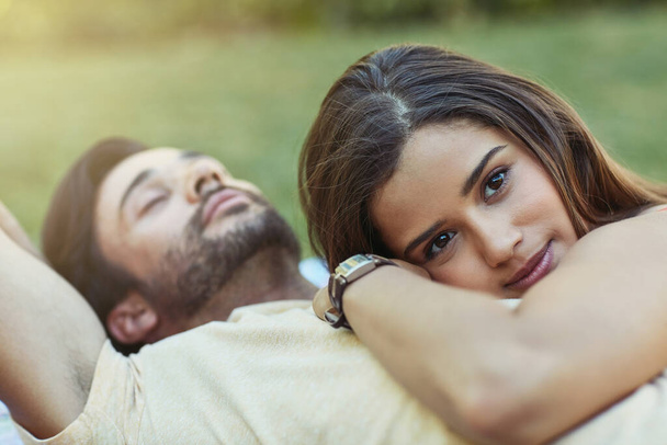 J'entends son cœur battre pour moi. Portrait d'un jeune couple affectueux couché dehors sur la pelouse ensemble - Photo, image