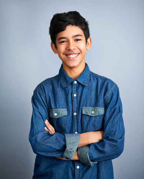 Smile, happy and portrait of teenager with fashion feeling confident arms crossed isolated in a gray studio background. Content, happiness and young Arab teen male person or teen with style. - 写真・画像