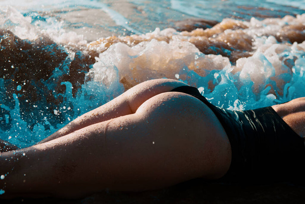 Sommer Hintern eines jungen Mädchens mit gebräuntem sexy Körper. fester Po im Bikini am Strand - Foto, Bild