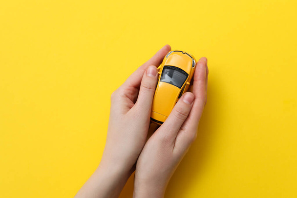 Concept van de aankoop van een auto en verzekering met speelgoed auto - Foto, afbeelding