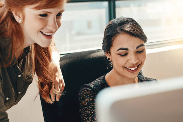 Nichts fördert die Produktivität so wie Teamarbeit. zwei junge Geschäftsfrauen benutzen gemeinsam einen Computer in einem modernen Büro - Foto, Bild