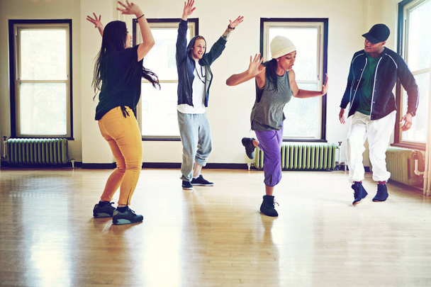 Nothing feels as good as dance. a group of young friends dancing together in a studio - Foto, imagen
