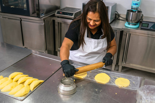 Колумбійський пекар весело посміхається на роботі. Типова колумбійська їжа - Фото, зображення