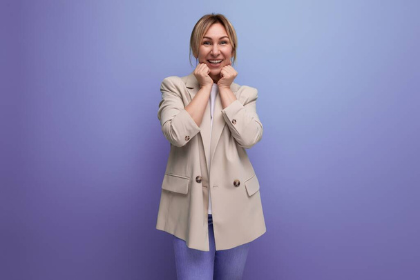 sorridente positivo tipo europeo giovane donna in una giacca su uno sfondo studio con spazio copia per la pubblicità. - Foto, immagini