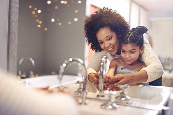Νερό, καθαρισμός και πλύσιμο χεριών από τη μητέρα και το παιδί σε ένα μπάνιο για μάθηση, υγιεινή και φροντίδα. Λεκάνη, πλύση και προστασία των χεριών από τη μαμά και το κορίτσι μαζί για την πρόληψη των βακτηρίων, βρωμιά και μικρόβια. - Φωτογραφία, εικόνα