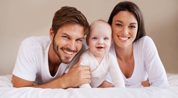 Happy portrait, dad and mom of baby kid on bed for love, care and quality time together to relax at home. Smile of family, parents and cute newborn child for development, caring support and happiness. - Foto, Imagem