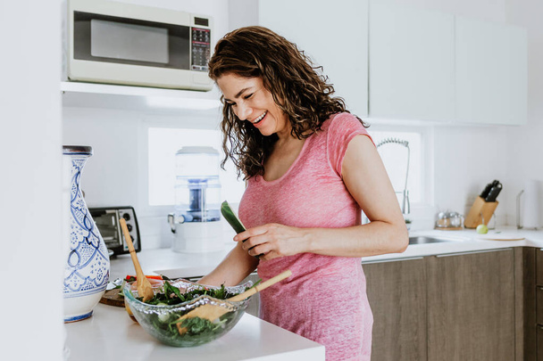 Latin adult woman preparing salad bowl in the kitchen at home in Mexico, Hispanic female in Latin America - Photo, Image