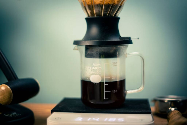 The Hario V60 Immersion Dripper preparing coffee on the blurred background - Fotó, kép