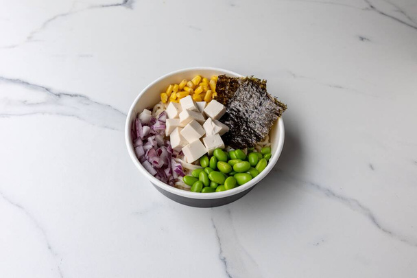 A tasty poke bowl with tofu cheese on the marble table - Φωτογραφία, εικόνα