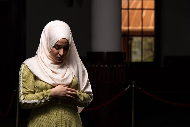 A portrait of a gorgeous humble Muslim woman praying in peace at a mosque - Photo, image