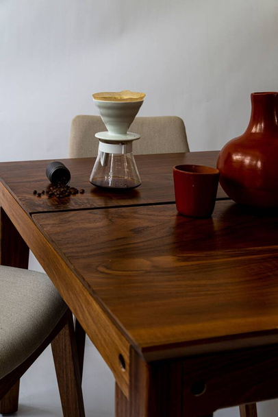 Vertikální záběr jídelního stolu, na něm položené kávové předměty, na bílém pozadí - Fotografie, Obrázek