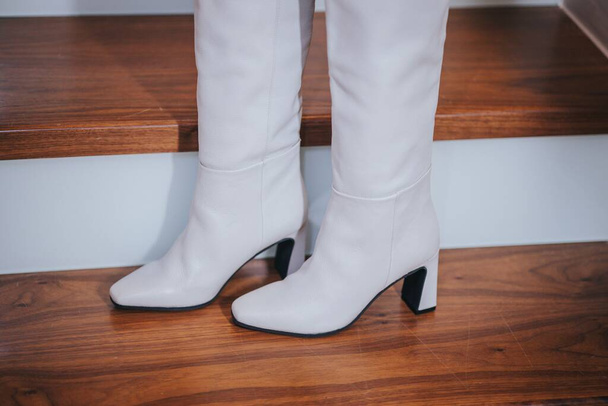 A closeup shot of white boots on a wooden stairs - Photo, Image