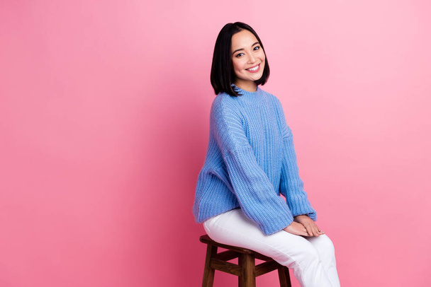 Portrait of stunning cheerful lady sit stool toothy smile empty space ad isolated on pink color background. - Фото, изображение