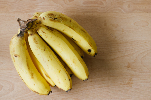 a bunch of ripe bananas on wooden background - Photo, Image