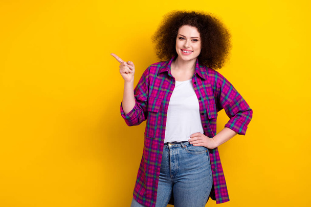 Photo of shiny adorable lady wear checkered jacket pointing finger empty space isolated yellow color background. - Foto, Imagen