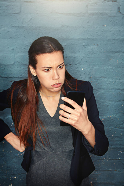 Its about time for a phone upgrade. an angry businesswoman looking at her phone in exasperation - Foto, immagini